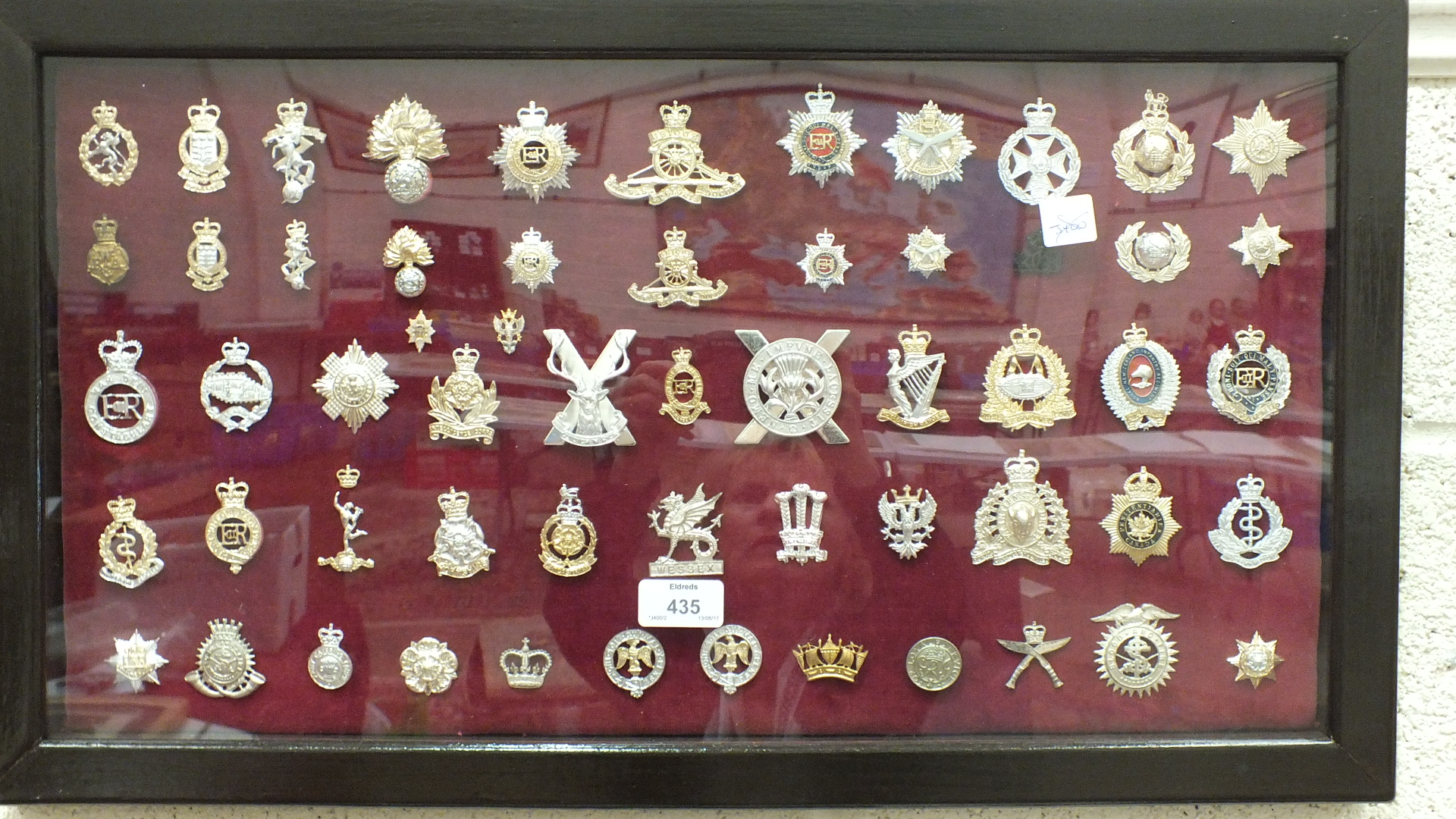 A collection of 117 various military badges contained in four glazed frames.