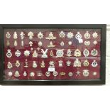 A collection of 117 various military badges contained in four glazed frames.