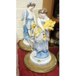 A pair of Continental unglazed parian ware figures of a young man and lady carrying flowers with a