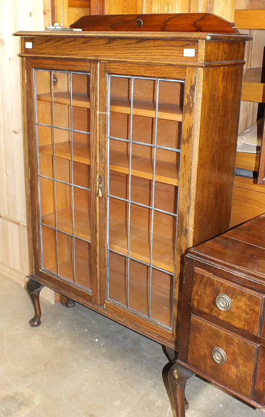 An oak bookcase, the rectangular top above a pair of leaded-light doors, on cabriole legs, 92cm
