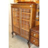 An oak bookcase, the rectangular top above a pair of leaded-light doors, on cabriole legs, 92cm