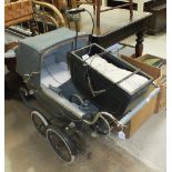 A dolls pram with tinplate body and wooden interior, 42cm long and a Silver Cross dolls pram, the