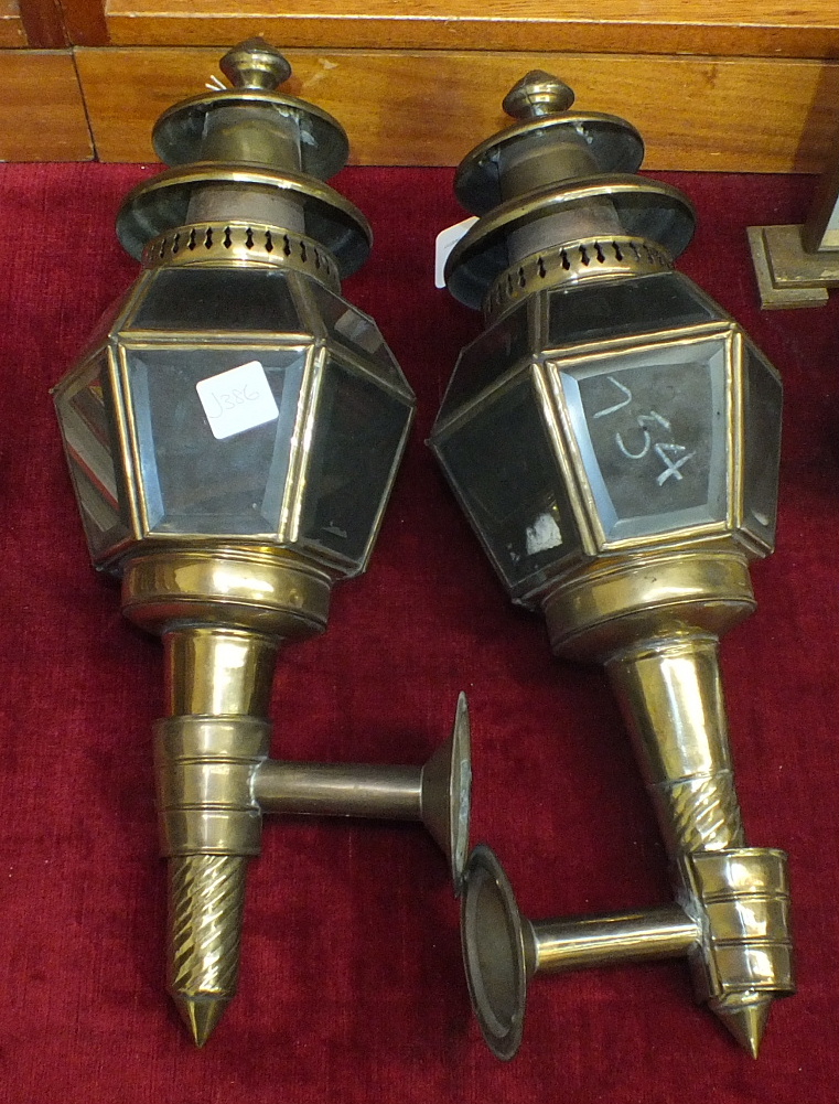 A pair of brass and glass hexagonal-shaped coaching lamps with brackets, 40cm.