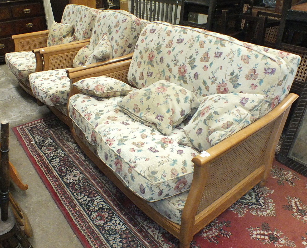 A modern Ercol Bergère-style light wood two-seater settee with cane sides and loose cushions and two