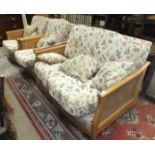 A modern Ercol Bergère-style light wood two-seater settee with cane sides and loose cushions and two