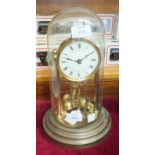 A brass 400-day clock, the dial with Roman numerals under glass dome, on circular base, 31cm high