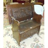 A mid-20th century oak monk's bench, 91cm wide, with carved top and hinged seat.