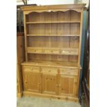 A modern pine dresser, the open shelves with three drawers above a base fitted with three drawers