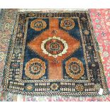 A small Baluch rug with central flower head on a brick red and blue ground, 115.5 x 118cm and one