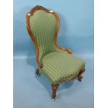 A Victorian walnut salon chair, the carved shaped back and serpentine upholstered seat on cabriole