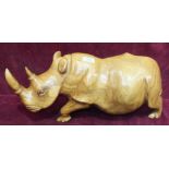 A large carved wood Rhinoceros, 22cm high, 53cm long.