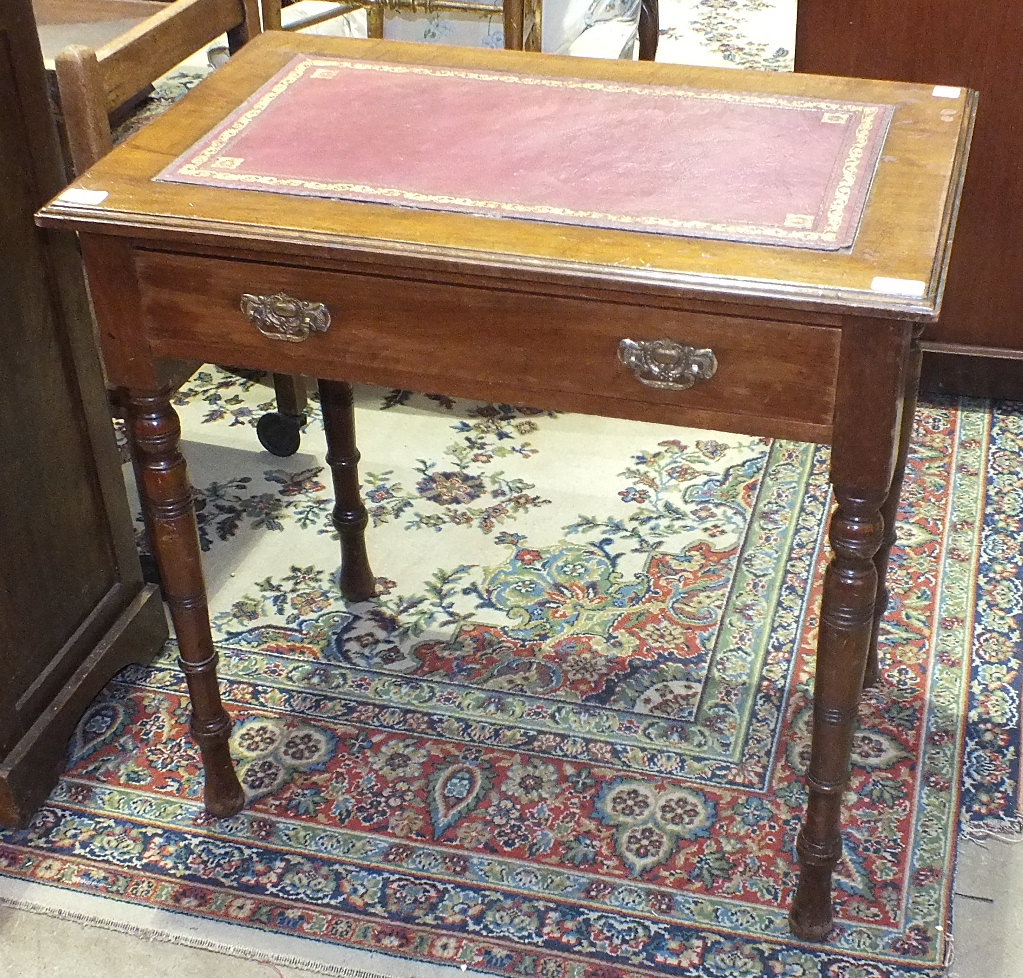 A stained mahogany writing table, the rectangular top with inset above a frieze drawer, on turned