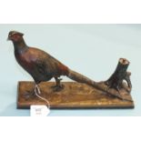 An Art Deco cold-painted table lighter cast as a pheasant beside a tree stump, on wooden base, 31.