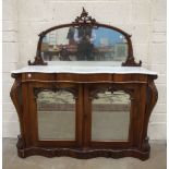 An early-Victorian rosewood side cabinet, the mirrored back with carved frame above a serpentine