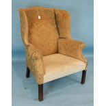 A Georgian-style wing armchair of generous proportions, on chamfered and moulded mahogany legs.