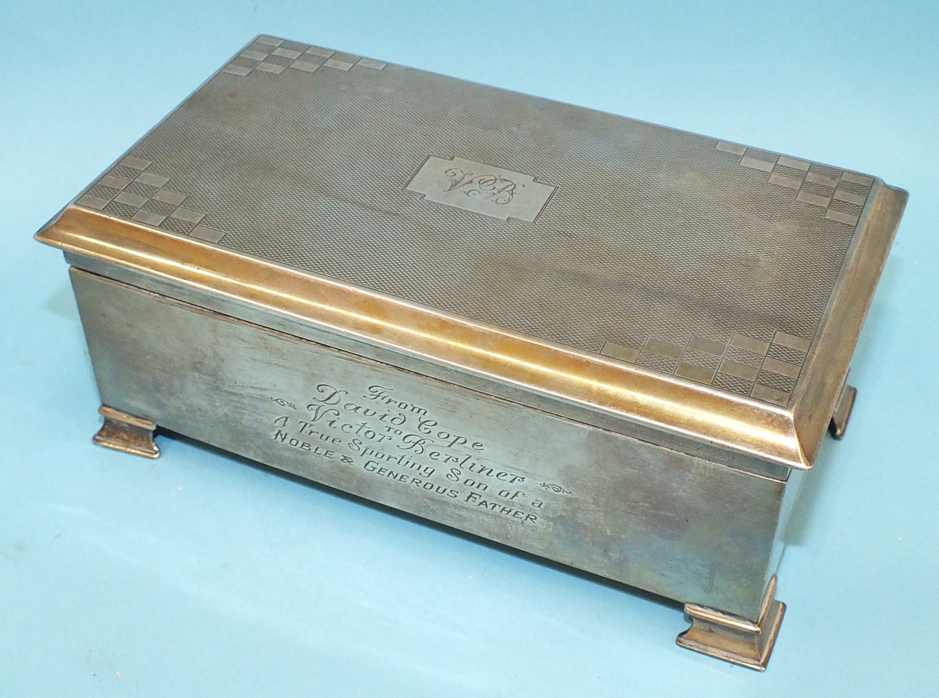 A rectangular engine-turned cigarette box on bracket feet, 18cm wide, Birmingham 1933.