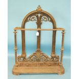 A Victorian cast iron umbrella stand, the arched foliate scrolling frame and plinth base with