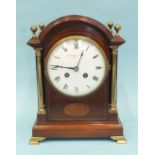 An early-20th century mahogany mantel clock of arched architectural form, the convex white dial