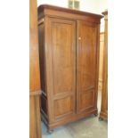 A pair of late-19th century Continental walnut wardrobes, each with single panelled door, moulded