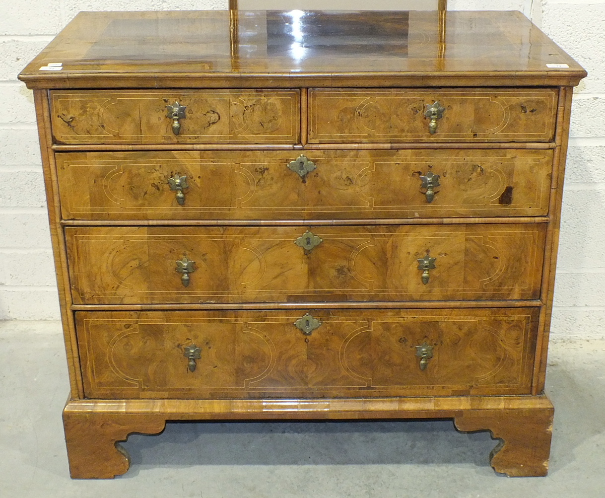 An early-18th century walnut chest, the cross-banded and quarter-veneered top above two short and