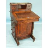 A Victorian walnut Davenport having four small drawers and pen and ink stand above the lift lid,