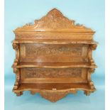 A 19th century Italian carved wall display shelf having three shaped serpentine shelves and