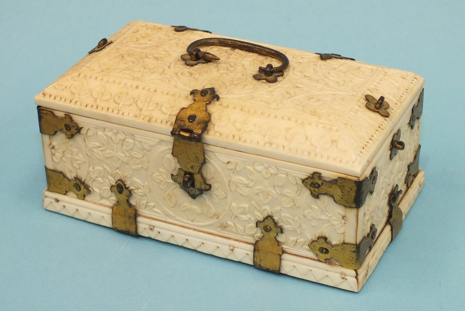 An early-20th century carved ivory and gilt-metal-bound casket carved with overall foliate design,