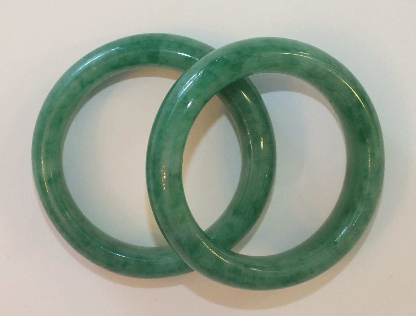 A pair of Chinese apple-green jade bangles, inner diameter 4.75cm, 128.8g, (2).