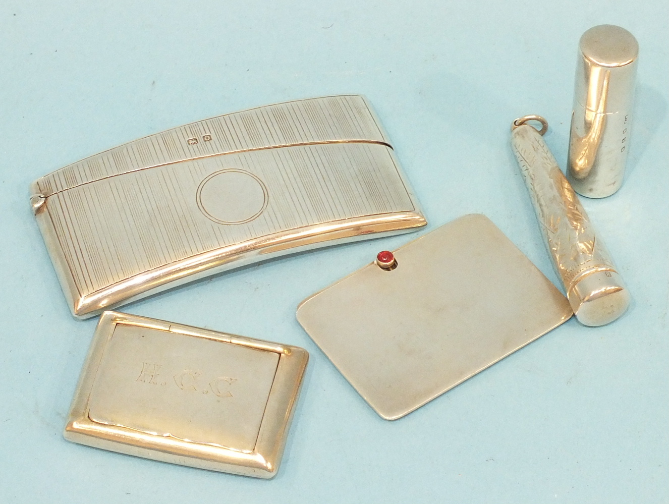 A silver card case of curved form, 8 x 4cm, Birmingham 1938, maker THH, a silver stamp case, two