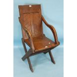 An antique oak X-frame chair with solid seat and panelled back, 56cm wide.