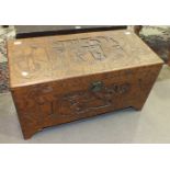 A 20th century camphor wood chest carved overall with figures, buildings and dragons, 90 x 43cm,