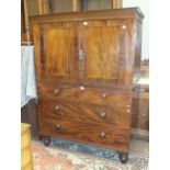 A 19th century small mahogany linen press, having a pair of panelled doors above two short and two