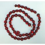 A string of alternate spherical and ovoid red amber-style Bakelite beads, 66cm.