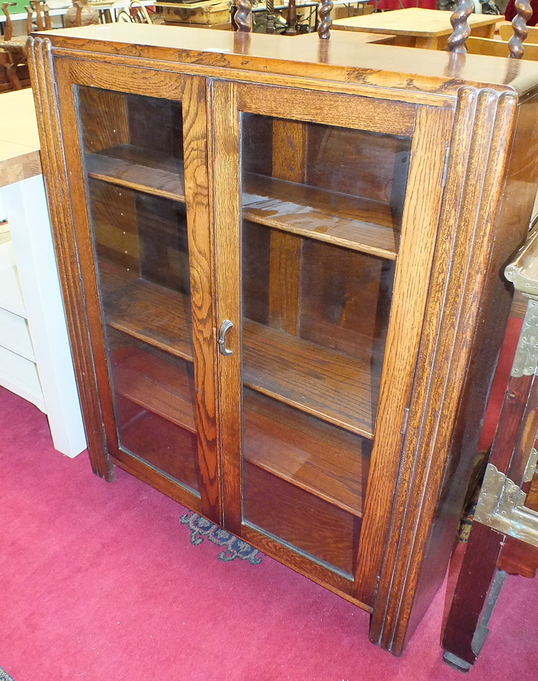 An oak low bookcase with a pair of glazed doors, 90cm wide, 115cm high, an oak occasional table