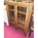 An oak low bookcase with a pair of glazed doors, 90cm wide, 115cm high, an oak occasional table