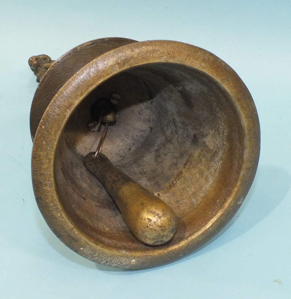 A Tibetan bronze hand bell of turned tapered form, the handle surmounted by a ceremonial cow, 28cm - Image 2 of 2