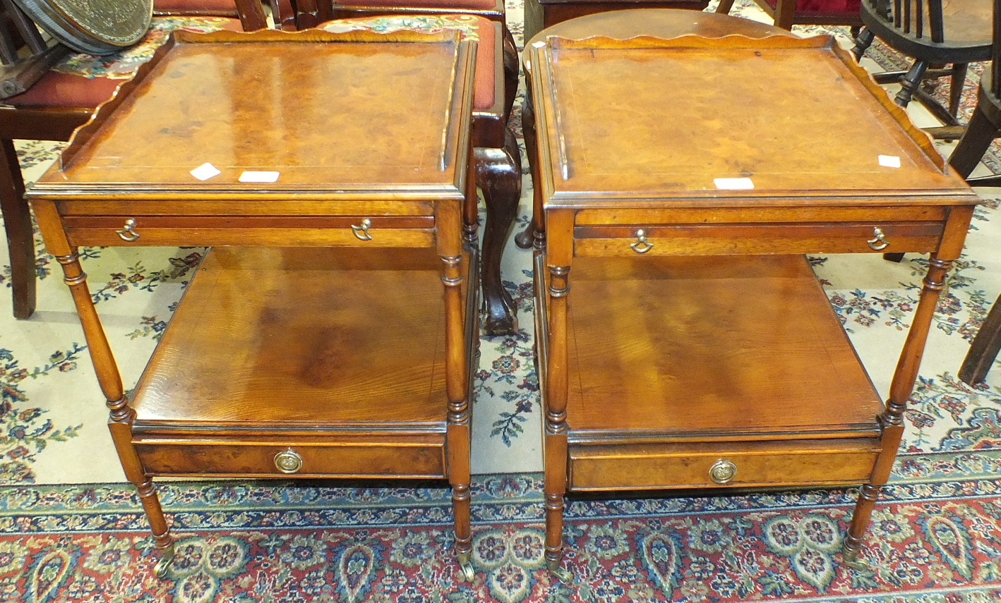 A pair of modern walnut bedside tables, each with a square galleried top above a slide, on turned