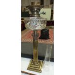 A Victorian brass Corinthian column oil lamp with clear cut-glass reservoir, 55cm high.