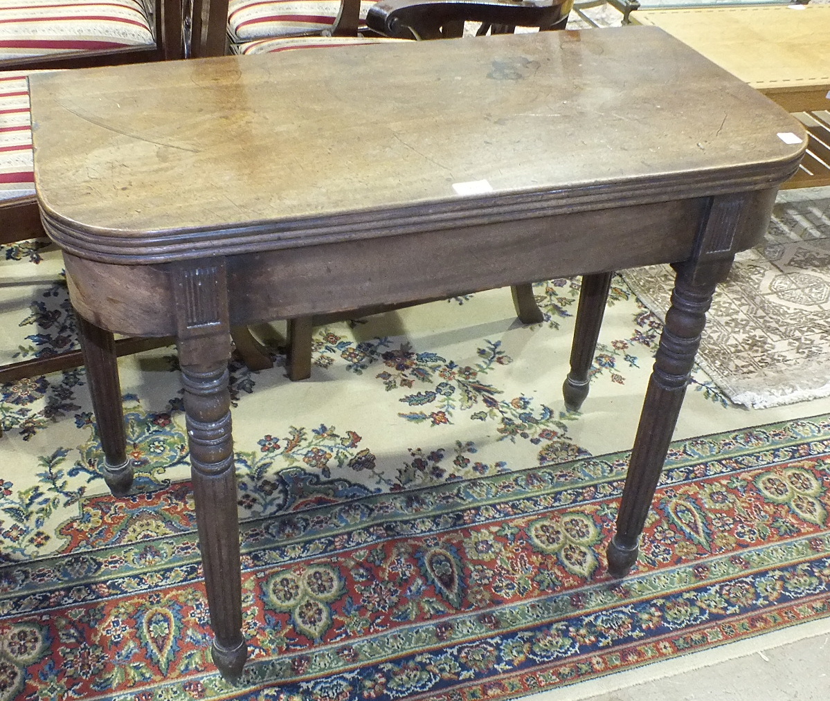 A 19th century mahogany fold-over tea table on turned legs, 91cm wide.