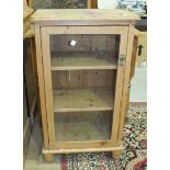 A stripped pine cupboard with single glazed door, 54cm wide, 94cm high and a pine single-drawer