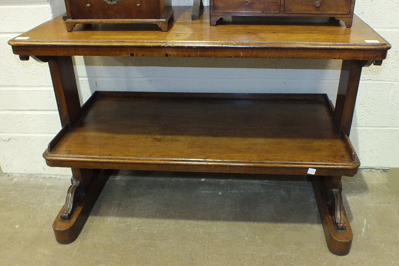 A late-19th century mahogany two-tier dumb waiter on carved end supports, 114cm wide, 78cm high.