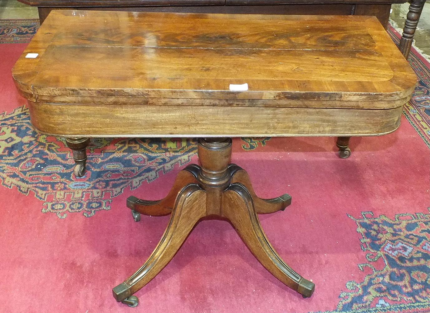 An early-19th century mahogany fold-over card table, (top split), on quadruped base, 94cm wide.