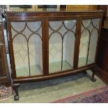 A mid-20th century mahogany display cabinet, the slightly-bowed rectangular top above three glazed