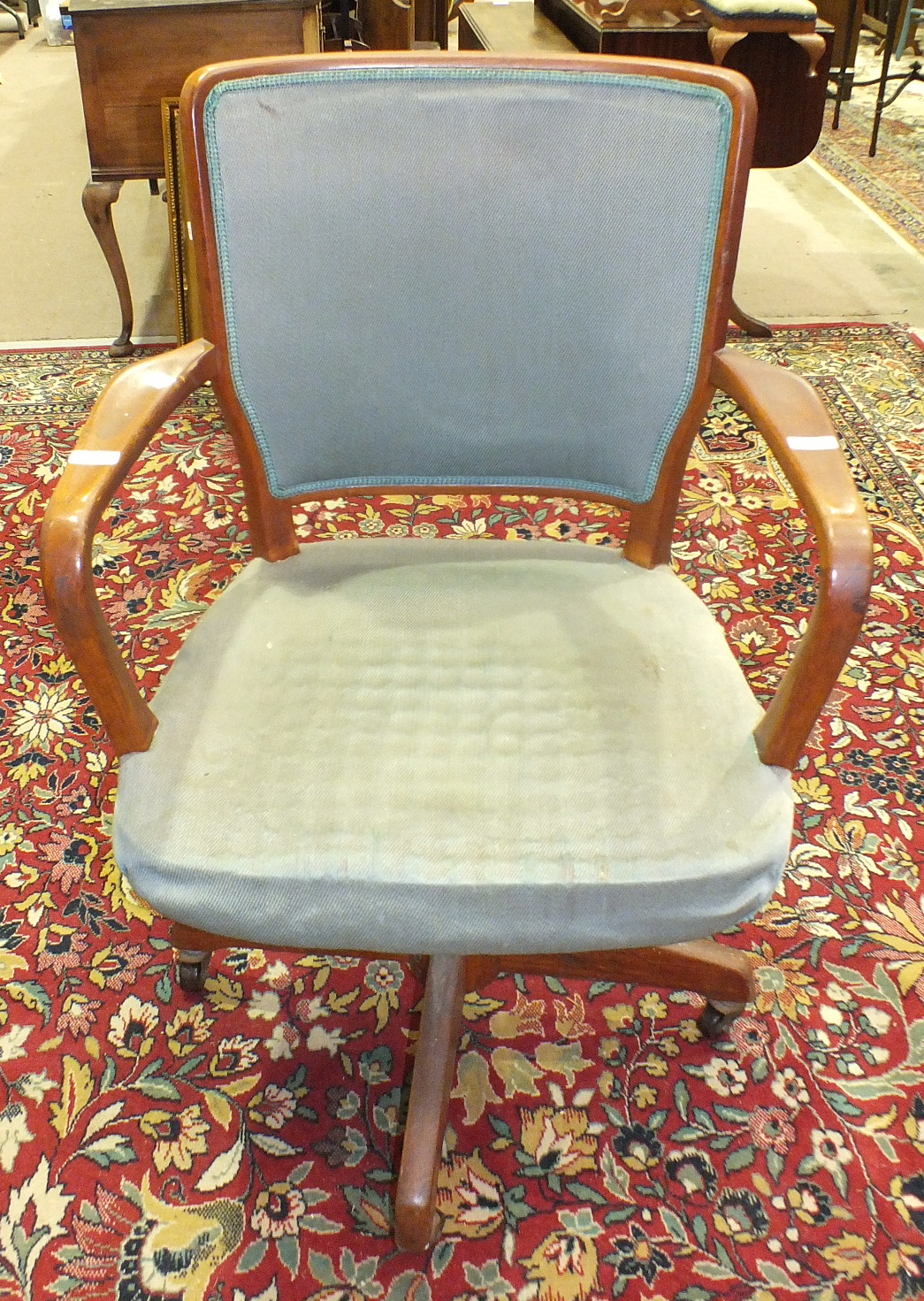 A mid-20th century hardwood swivel office armchair with upholstered back and seat.