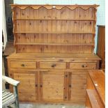 A modern pine dresser, the open-shelved top above three drawers and three cupboard doors, 167cm