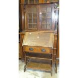 An Edwardian low oak bureau bookcase, the top fitted with a pair of glazed doors above a fall front,