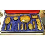 An early-20th century tortoiseshell part dressing table set inlaid with gilt dragons, in a fitted