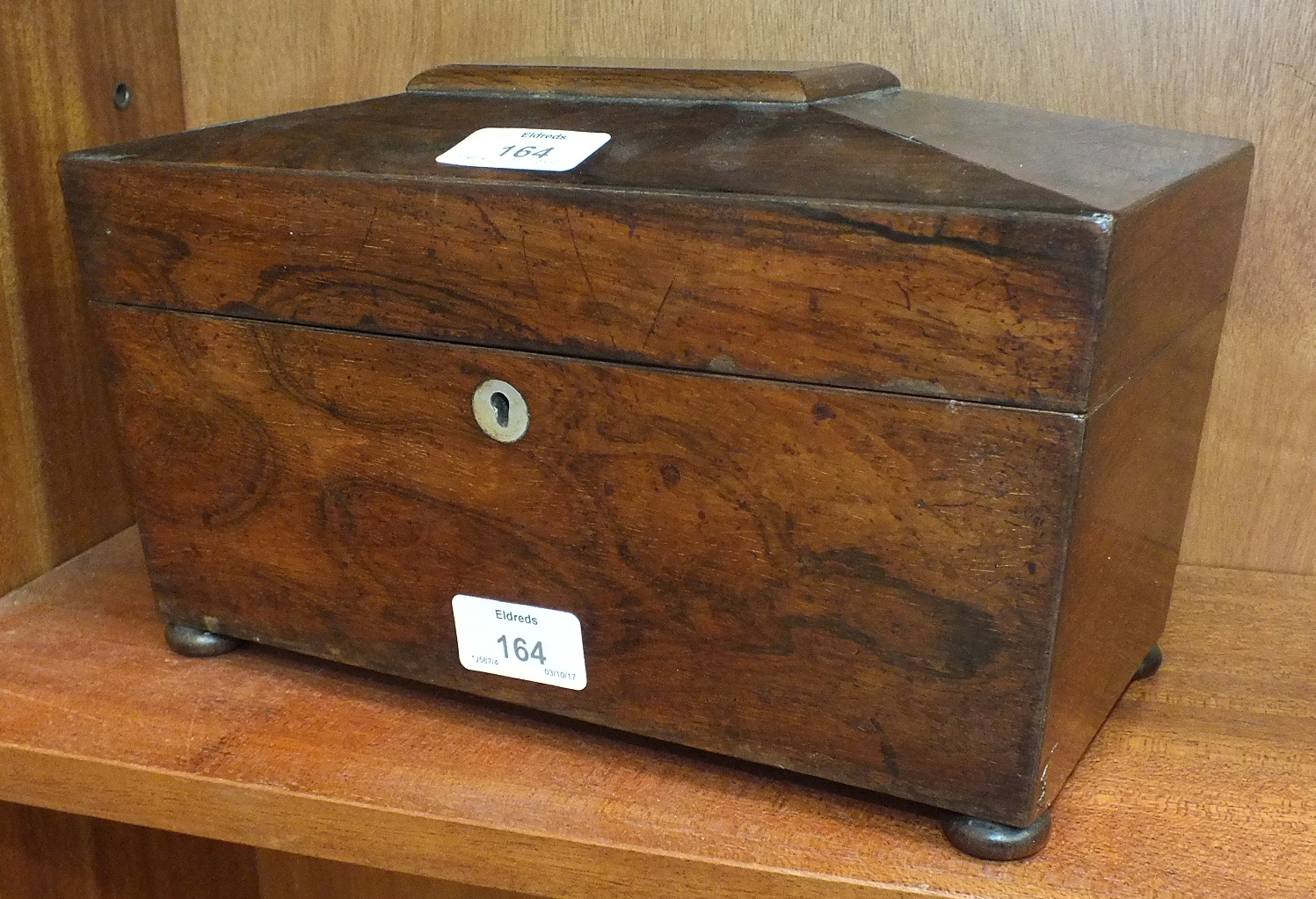 A 19th century rosewood tea caddy of sarcophagus shape, the interior with two containers and