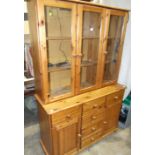 A modern pine dresser, the shelves enclosed by three glazed doors above three drawers and three