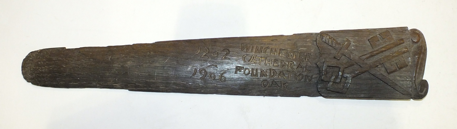 A carved oak page turner from "Winchester Cathedral Foundation Oak 1202-1906", carved with cross